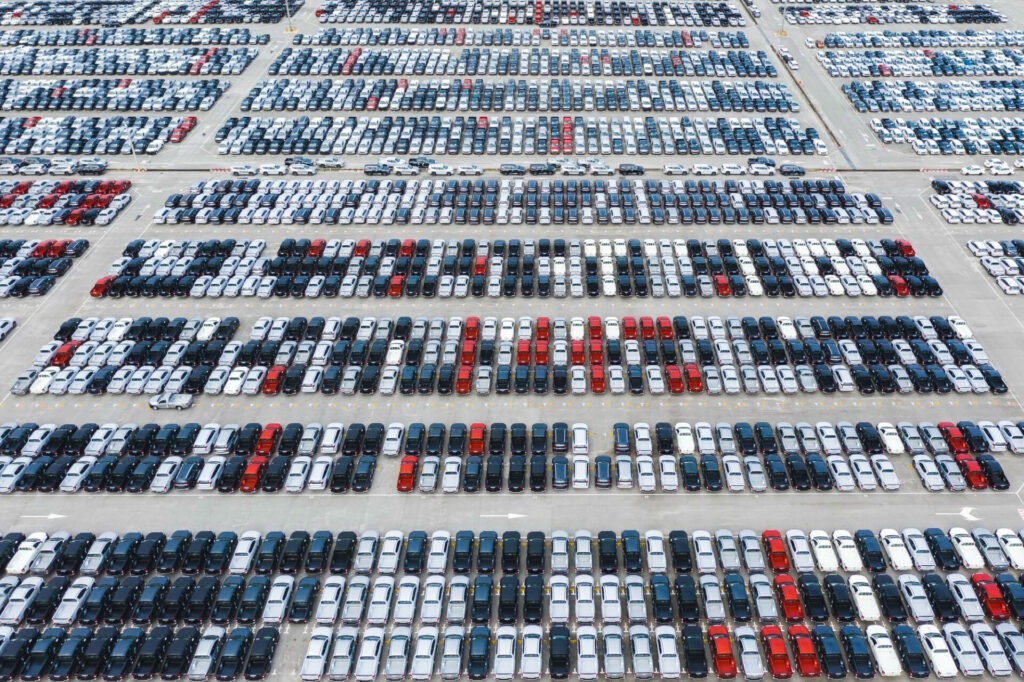 Vue aérienne d’un immense parc automobile illustrant la gestion des stocks et l’importance d’un centre de contact performant pour fluidifier les ventes et livraisons